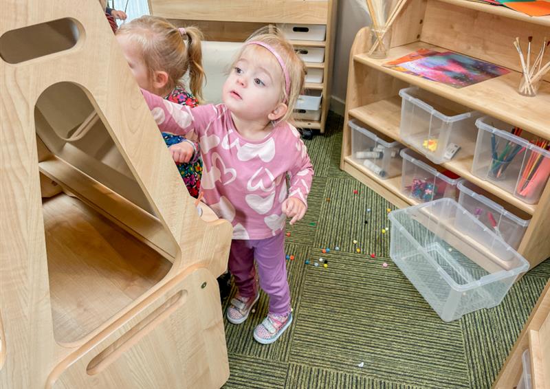 A little girl is engaging with a Millhouse art easel and is creating a piece of art